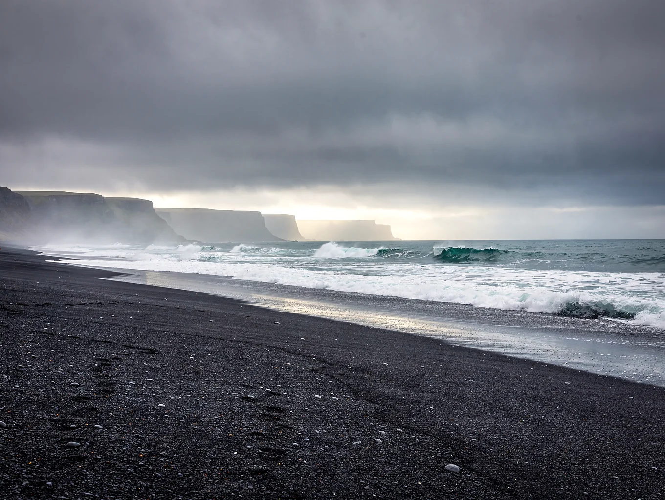 Black sand ripples foregrounding jagged Vestrahorn mountain under overcast sky